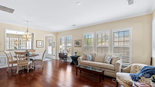living room with an inviting chandelier, dark wood-style floors, and visible vents