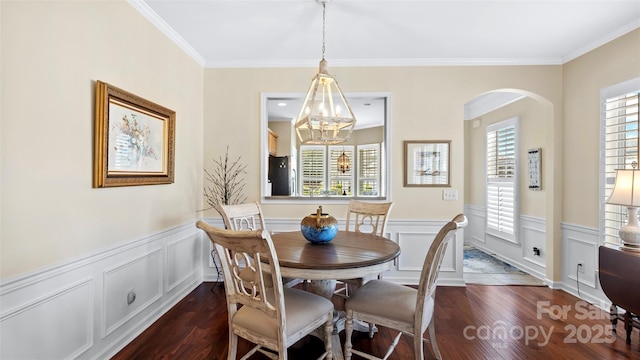 dining area with dark wood-type flooring, arched walkways, and plenty of natural light