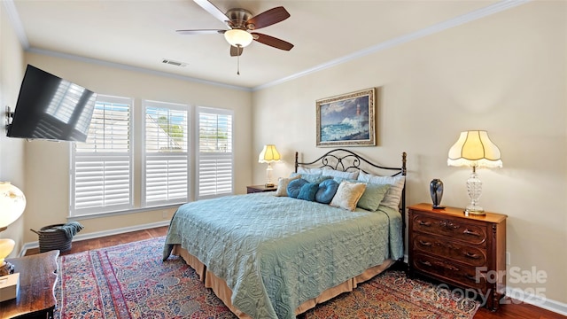 bedroom with visible vents, baseboards, crown molding, and wood finished floors