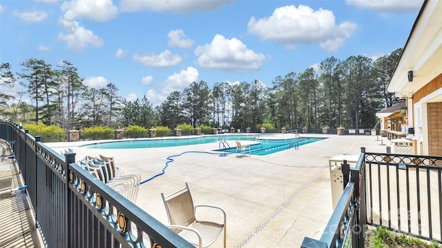 pool with a patio and fence