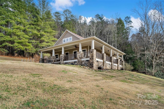 country-style home with ceiling fan, covered porch, and a front lawn