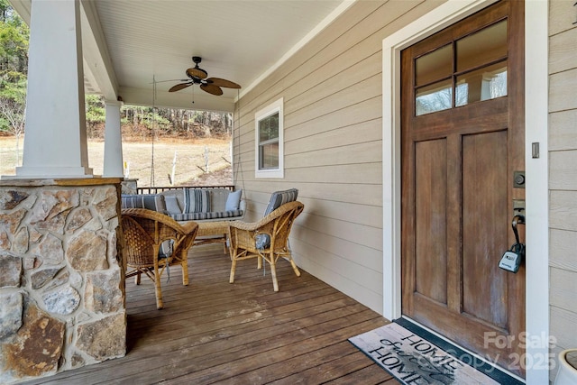 wooden terrace featuring ceiling fan and a porch