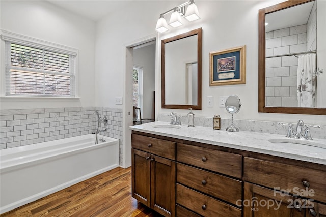 bathroom with hardwood / wood-style floors, vanity, and a washtub