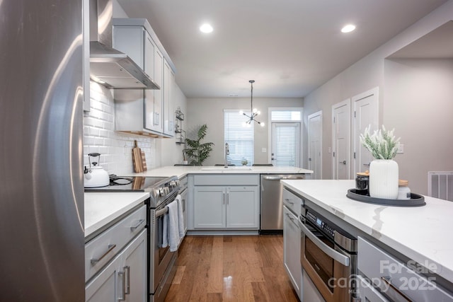 2306 Elizabeth Mill Pl, Charlotte, NC 28208 - kitchen featuring dark wood-style flooring, wall chimney exhaust hood, stainless steel appliances, a sink, and pendant lighting