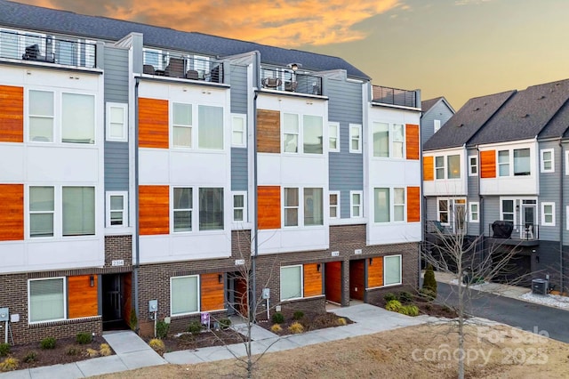 townhome / multi-family property with brick siding and stucco siding