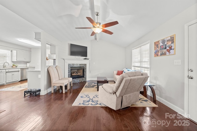 living room with lofted ceiling, dark wood-type flooring, sink, and a fireplace