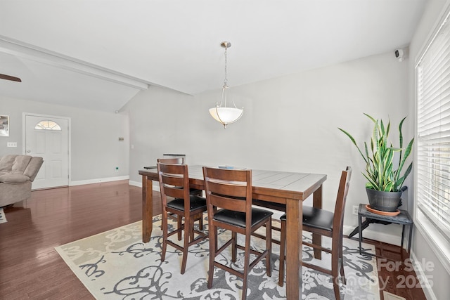 dining room with dark wood-type flooring and lofted ceiling with beams