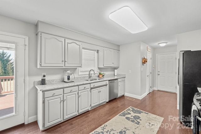 kitchen with dark hardwood / wood-style floors, white cabinetry, sink, stainless steel appliances, and plenty of natural light