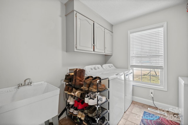 washroom with sink, cabinets, independent washer and dryer, a textured ceiling, and light tile patterned flooring