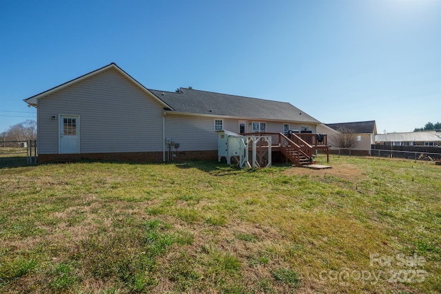 rear view of property featuring a yard and a deck