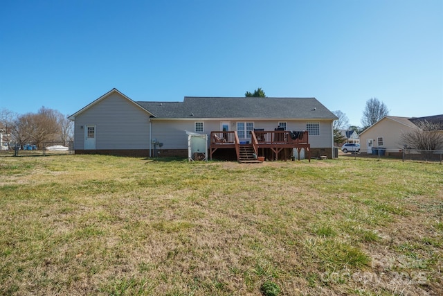 rear view of house featuring a wooden deck and a yard