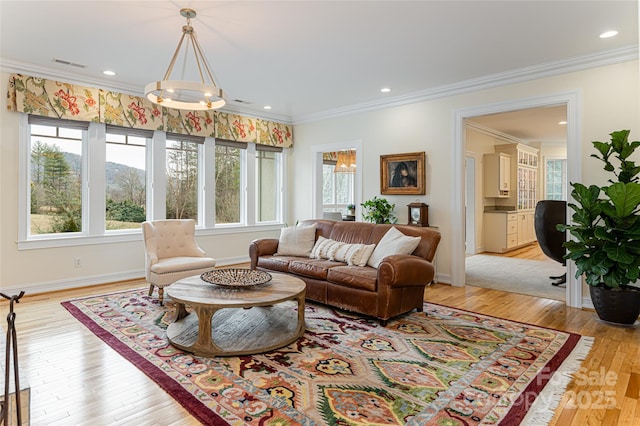 living room featuring light hardwood / wood-style flooring, crown molding, and plenty of natural light