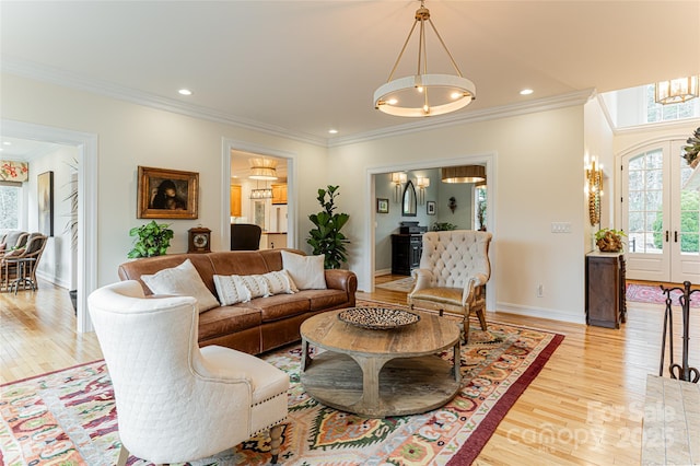 living room with ornamental molding, french doors, and light wood-type flooring