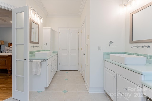 bathroom featuring tile patterned flooring, crown molding, and vanity