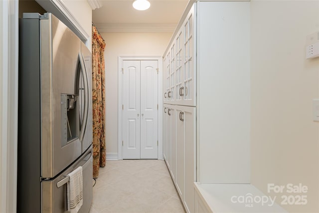 kitchen featuring light tile patterned floors, crown molding, white cabinets, and stainless steel refrigerator with ice dispenser