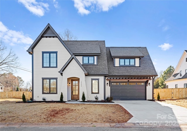 view of front of house featuring concrete driveway, roof with shingles, fence, and an attached garage