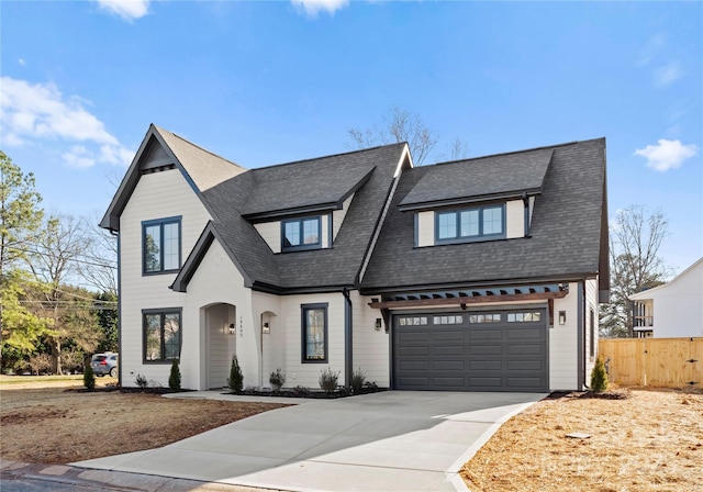 view of front of house featuring driveway, fence, and roof with shingles