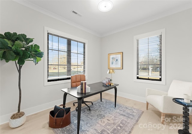 office area featuring baseboards, visible vents, crown molding, and wood finished floors