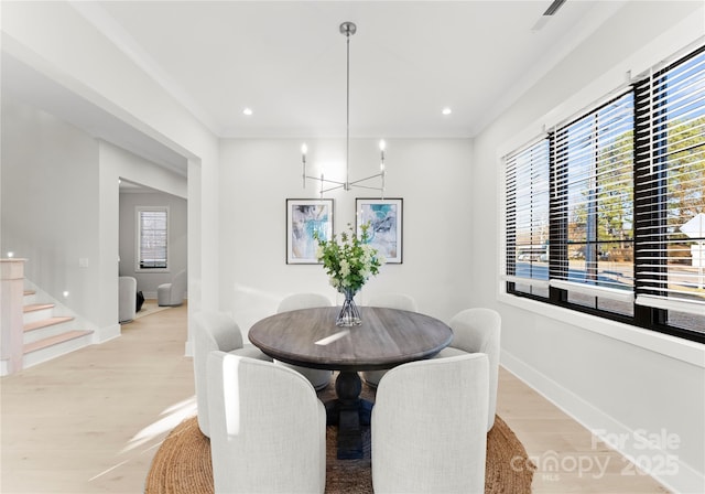 dining space featuring a notable chandelier, visible vents, baseboards, stairs, and light wood finished floors