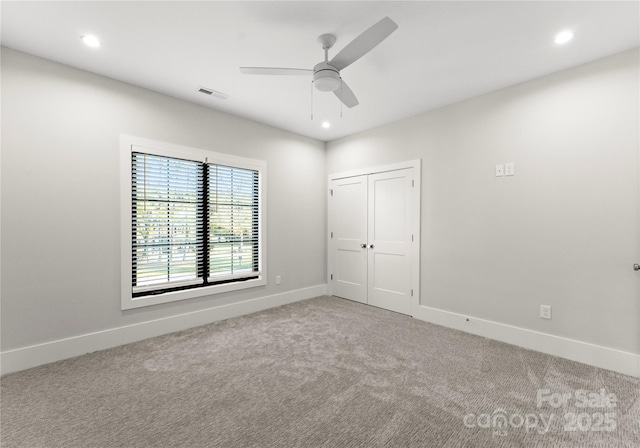 carpeted empty room with ceiling fan, recessed lighting, visible vents, and baseboards