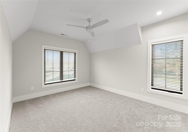 interior space with carpet floors, vaulted ceiling, baseboards, and ceiling fan