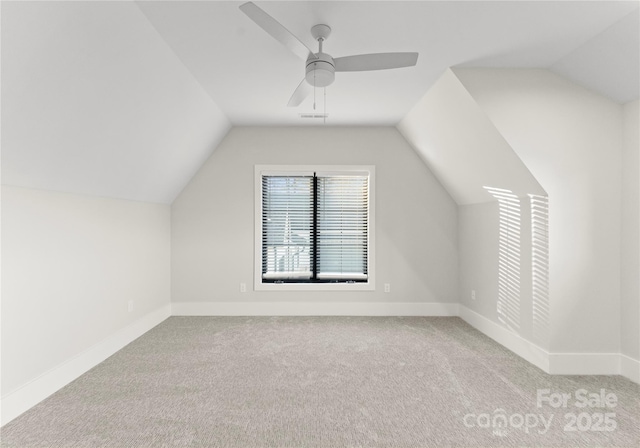 bonus room featuring ceiling fan, baseboards, vaulted ceiling, and light colored carpet