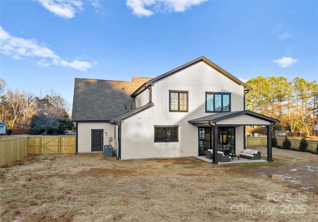 rear view of property with a gate, a patio area, a fenced backyard, and central AC unit