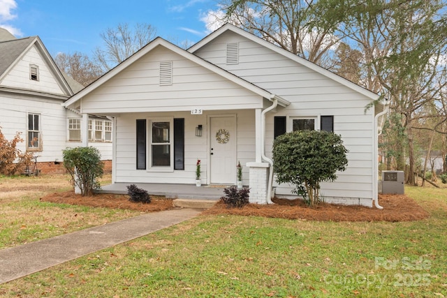 bungalow-style home featuring covered porch and a front yard