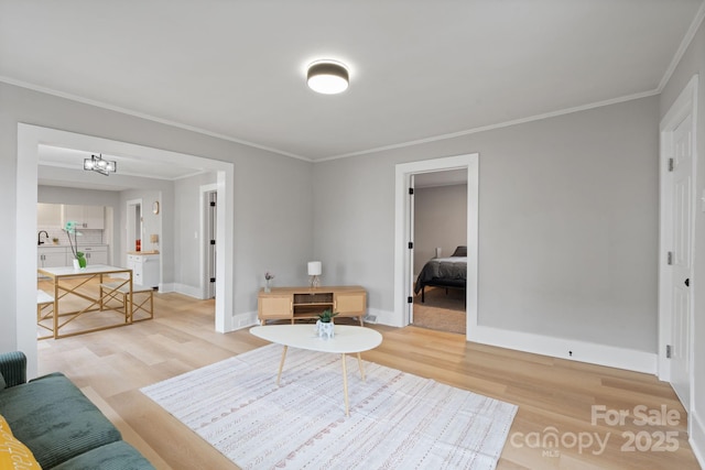 living room featuring hardwood / wood-style floors, crown molding, sink, and a chandelier