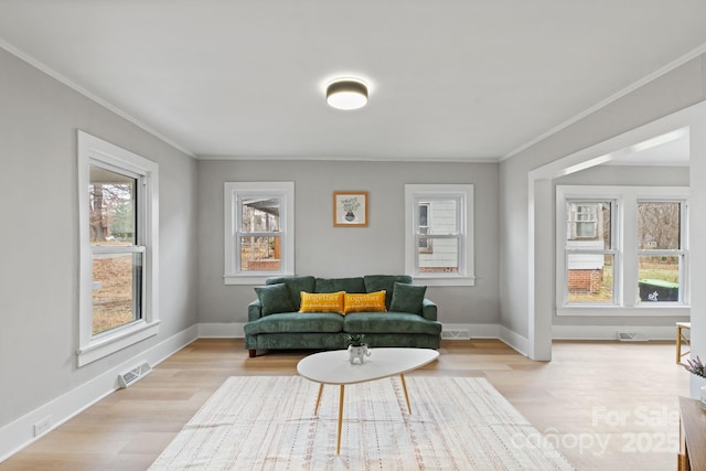 sitting room with crown molding and light hardwood / wood-style floors