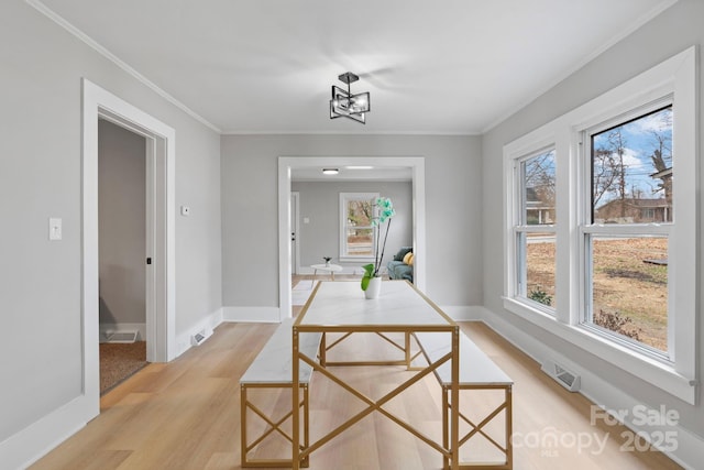 dining area featuring crown molding and light hardwood / wood-style floors