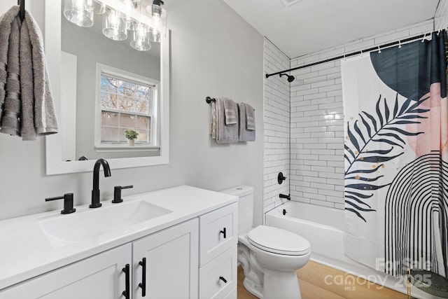 full bathroom with vanity, shower / tub combo with curtain, and toilet