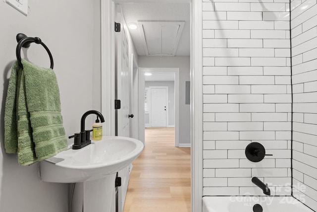 bathroom featuring tiled shower / bath combo and hardwood / wood-style floors