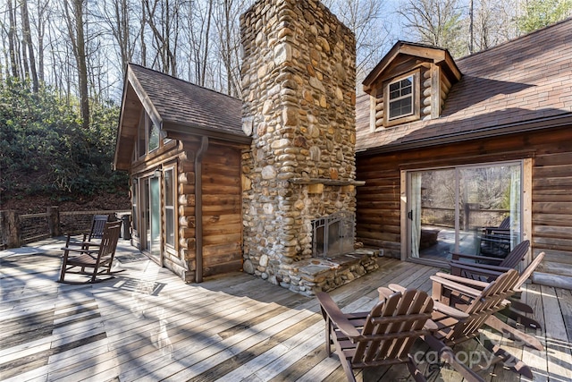 wooden terrace featuring an outdoor stone fireplace