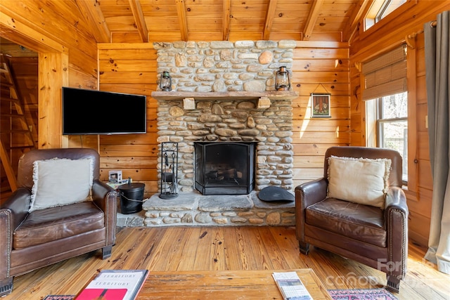 living area featuring wooden walls, wooden ceiling, a fireplace, and lofted ceiling with beams