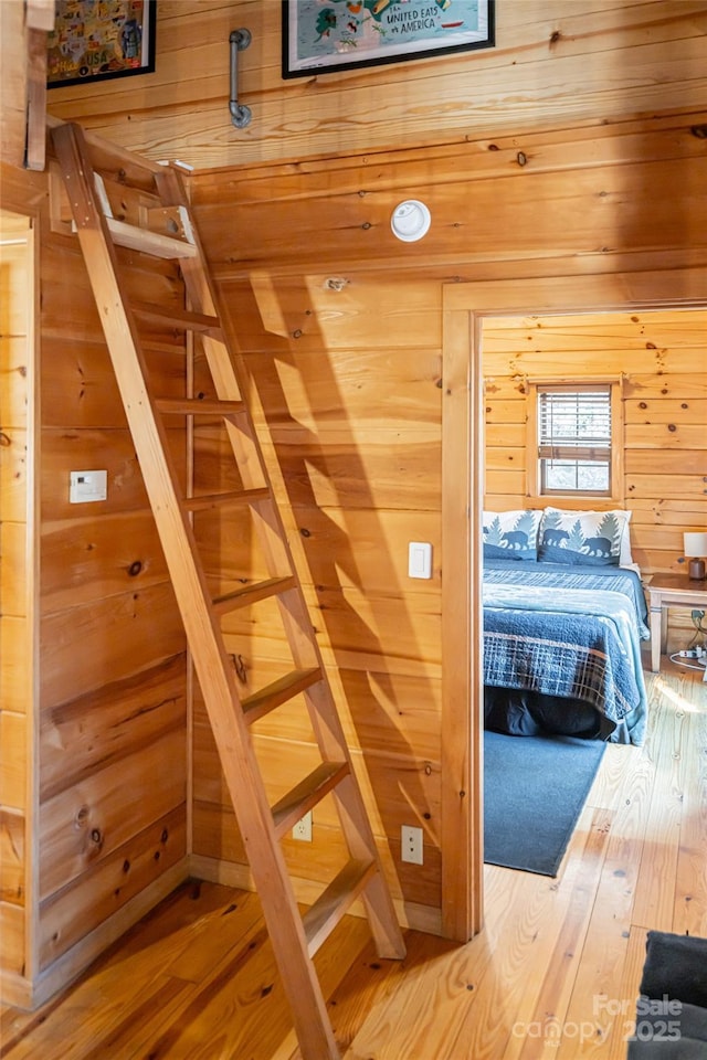 bedroom featuring wood finished floors and wooden walls