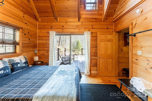 bedroom featuring lofted ceiling with beams, wooden ceiling, wooden walls, access to outside, and multiple windows