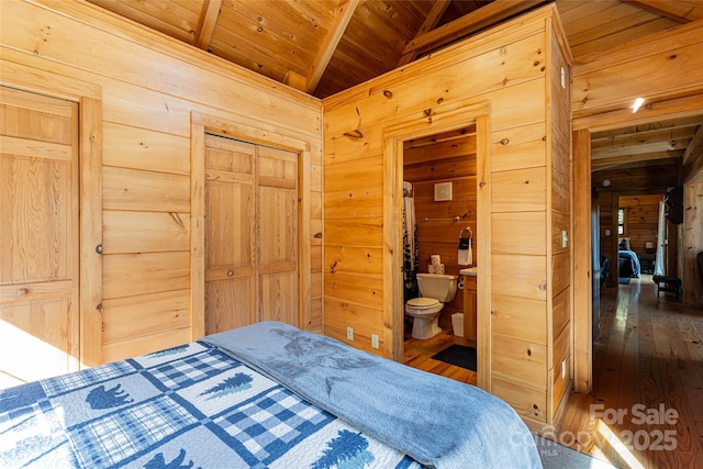 bedroom with wooden ceiling, wooden walls, dark wood-style floors, and vaulted ceiling