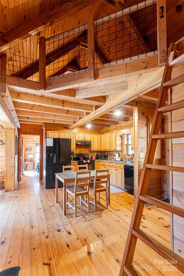 dining area with wooden ceiling, light wood finished floors, wooden walls, and beam ceiling