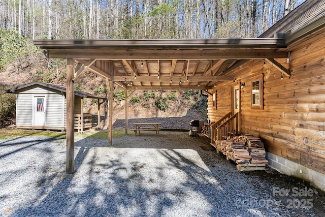 view of car parking with an attached carport, entry steps, and a shed