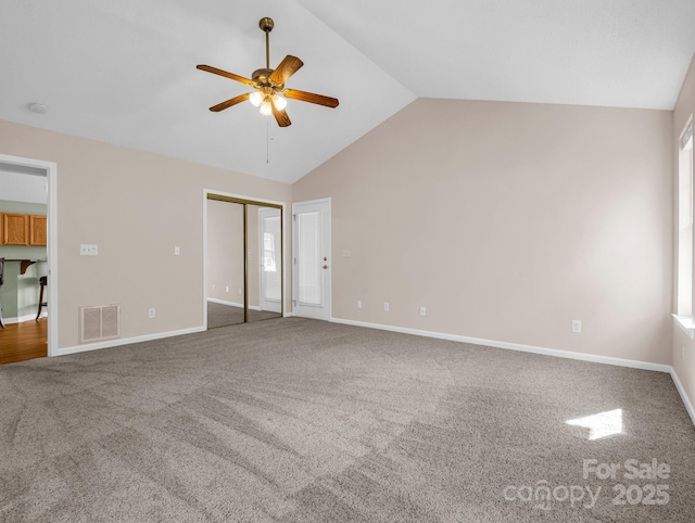 unfurnished bedroom featuring visible vents, carpet flooring, baseboards, and vaulted ceiling