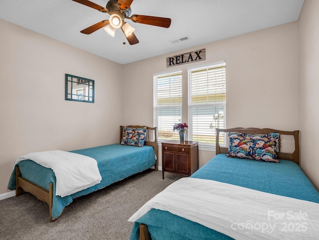 carpeted bedroom with visible vents, baseboards, and ceiling fan