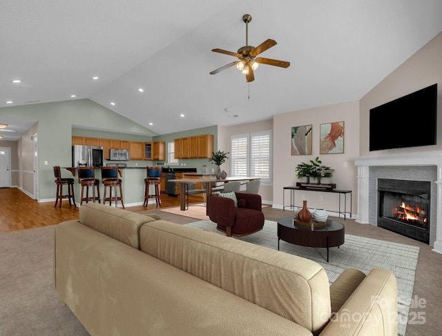 living area with a lit fireplace, recessed lighting, baseboards, and a ceiling fan