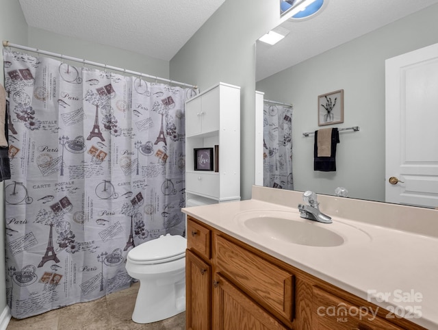 full bath featuring toilet, curtained shower, a textured ceiling, tile patterned flooring, and vanity