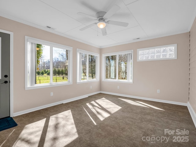 spare room with visible vents, baseboards, a ceiling fan, and ornamental molding