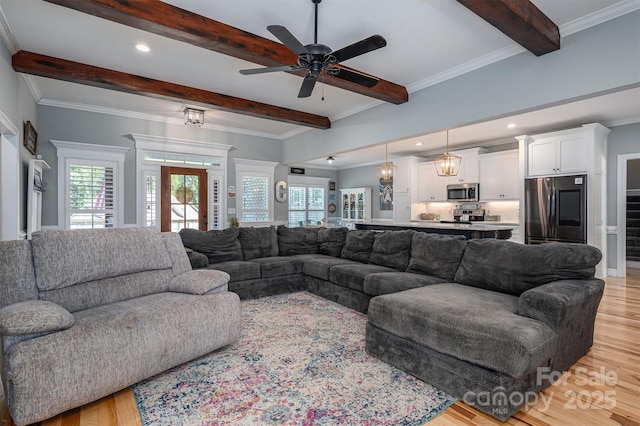 living area featuring beam ceiling, crown molding, and light wood-style floors