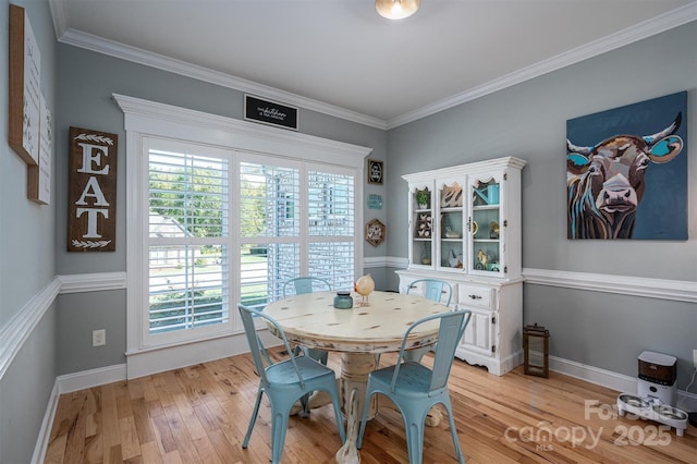 dining space with light wood-style flooring, baseboards, and ornamental molding