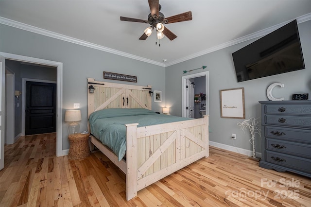 bedroom featuring ceiling fan, light wood-type flooring, crown molding, and a walk in closet