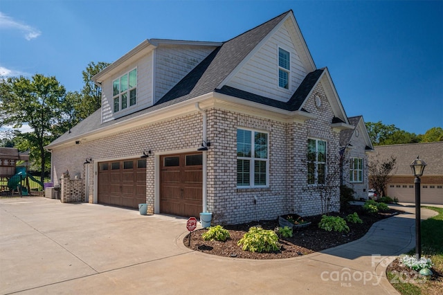 view of side of home featuring brick siding, an attached garage, and driveway