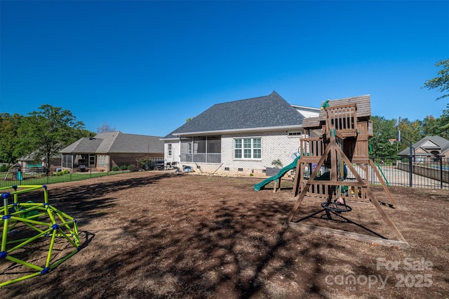 rear view of house featuring a playground and a sunroom